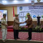 Ketua Umum SMSI Firdaus didampingi Ketua Cabang SMSI Kepri Zakmi menyerahkan anugerah Sahabat Pers Indonesia kepada Gubernur Ansar.