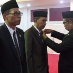 PAW Syarifuddin dan Dirja Muzakkir Ketua DPRD Karimun M Yusuf Sirat menyematkan lencana kepada Dirha Muzakir (kanan) dan Syarifuddin yang dilantik sebagai PAW Sri Rezeki dan Charli Donna Sitorus dalam rapat paripurna di Gedung DPRD Karimun, Rabu (9/8/2023). (dok. Diskominfo Karimun)