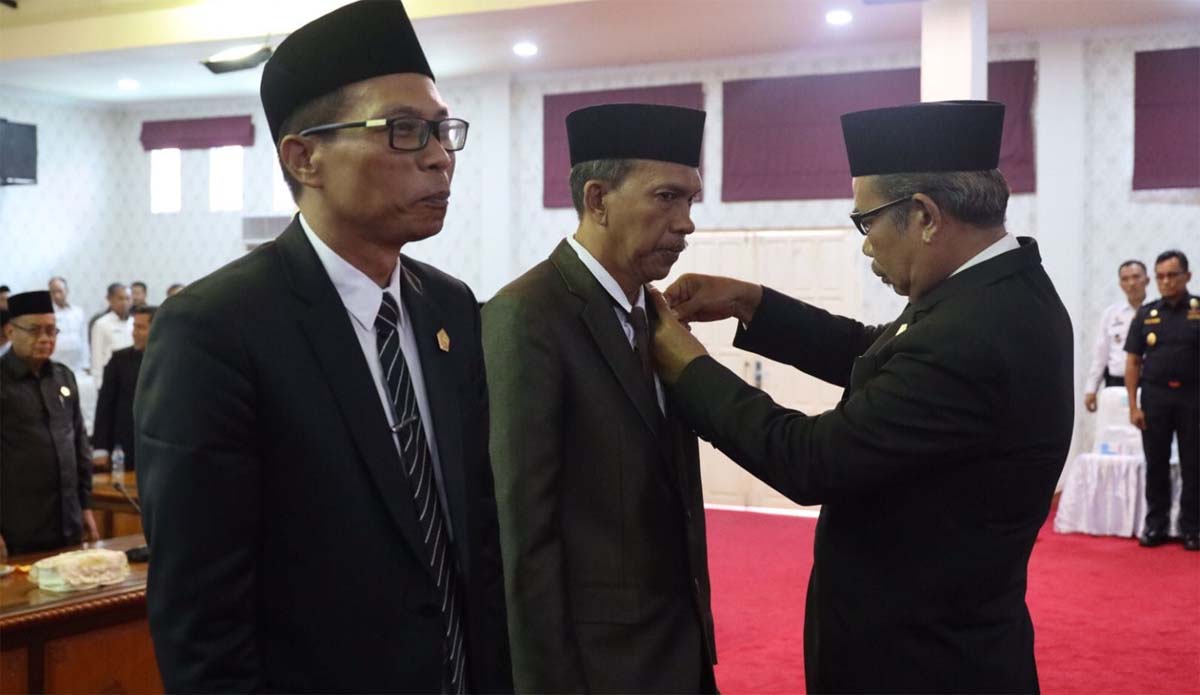 Ketua DPRD Karimun M Yusuf Sirat menyematkan lencana kepada Dirha Muzakir (kanan) dan Syarifuddin yang dilantik sebagai PAW Sri Rezeki dan Charli Donna Sitorus dalam rapat paripurna di Gedung DPRD Karimun, Rabu (9/8/2023). (dok. Diskominfo Karimun)
