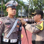 Kapolres Karimun AKBP Riky W Muharram menyematkan pita kepada personel yang terlibat dalam Operasi Zebra Seligi 2023 di lapangan Bhayangkara, Mapolres Karimun, Senin (4/9/2023). (Dok. Humas Polres Karimun)