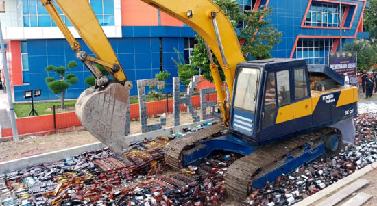Sebuah alat berat menggilas satu juta batang lebih rokok ilegal dan ribuan botol minuman beralkohol senilai Rp38,38 miliar di Kanwil DJBC Khusus Kepri, Meral, Kabupaten Karimun, Jumat (8/12/2023). (Dokumentasi pribadi)